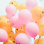 pink and yellow balloons smiling