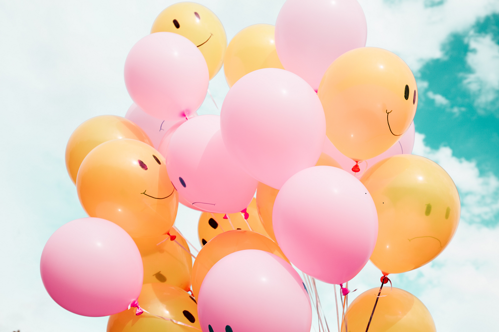 pink and yellow balloons smiling