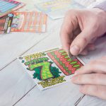Man scratches lottery scratchcard.