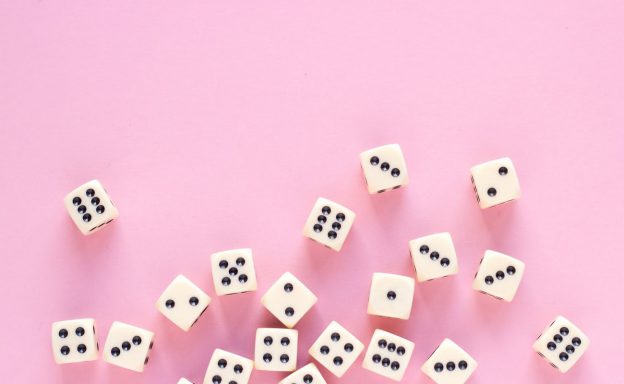 aming dice with copy space on pink background