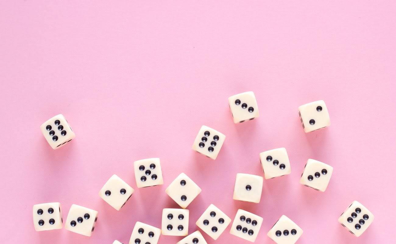 aming dice with copy space on pink background