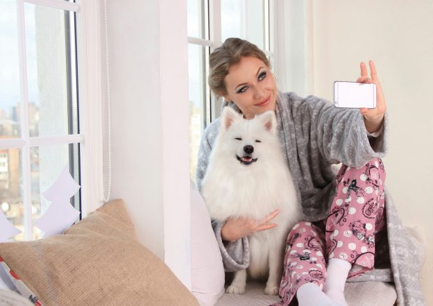 woman-taking-a-photo-of-herself-with-white-dog
