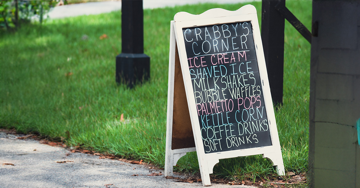 Image of Outdoor Chalkboard Sign with Writing Related to Food (E.g ‘Burgers Here’) Summer Feast