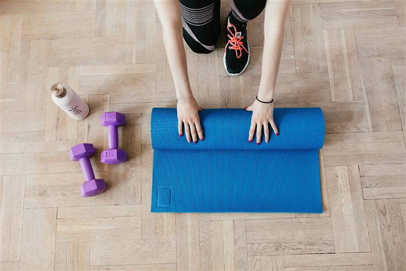 Someone rolling back his exercise mat after training.